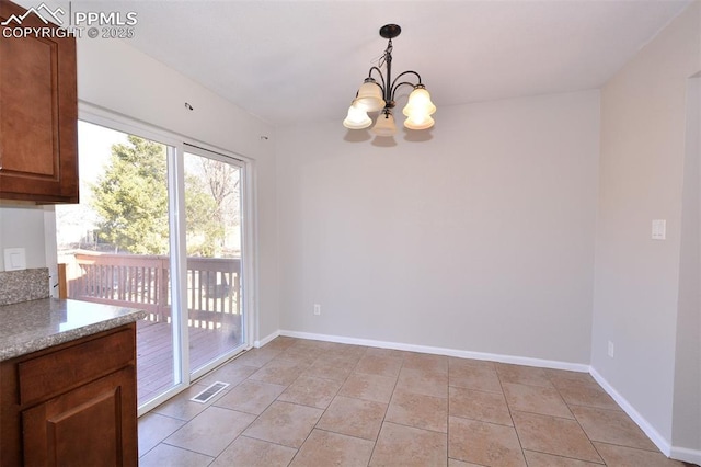 unfurnished dining area featuring an inviting chandelier and light tile patterned floors