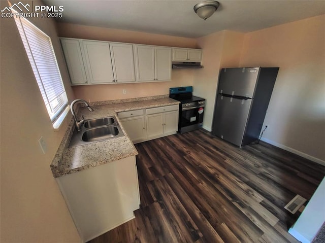 kitchen featuring light countertops, appliances with stainless steel finishes, white cabinetry, a sink, and under cabinet range hood