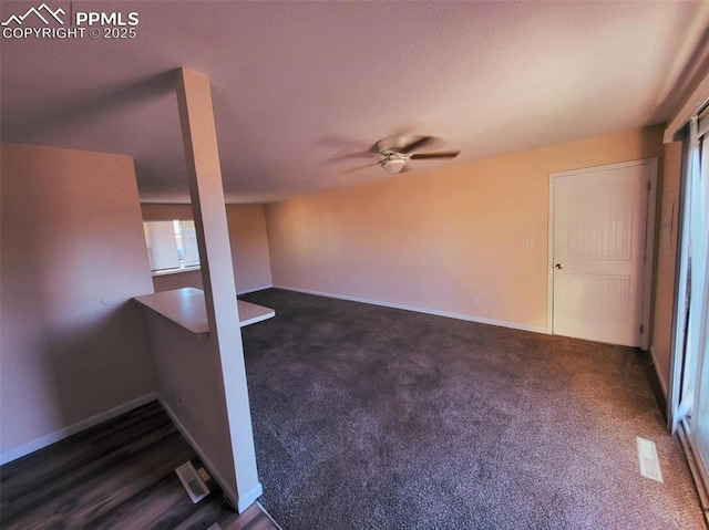 carpeted empty room with ceiling fan and baseboards