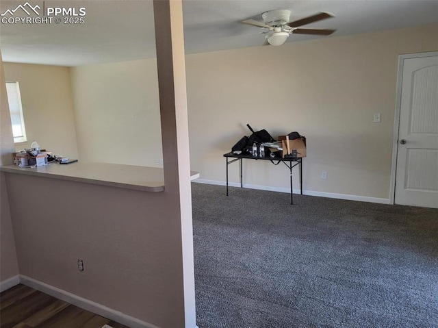 carpeted spare room featuring a ceiling fan and baseboards