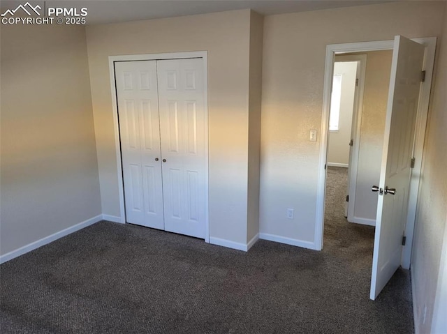 unfurnished bedroom with a closet, carpet flooring, and baseboards