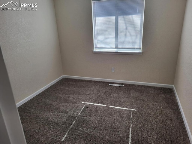 carpeted spare room featuring baseboards