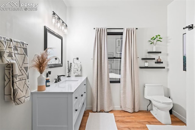 bathroom with hardwood / wood-style floors, vanity, and toilet