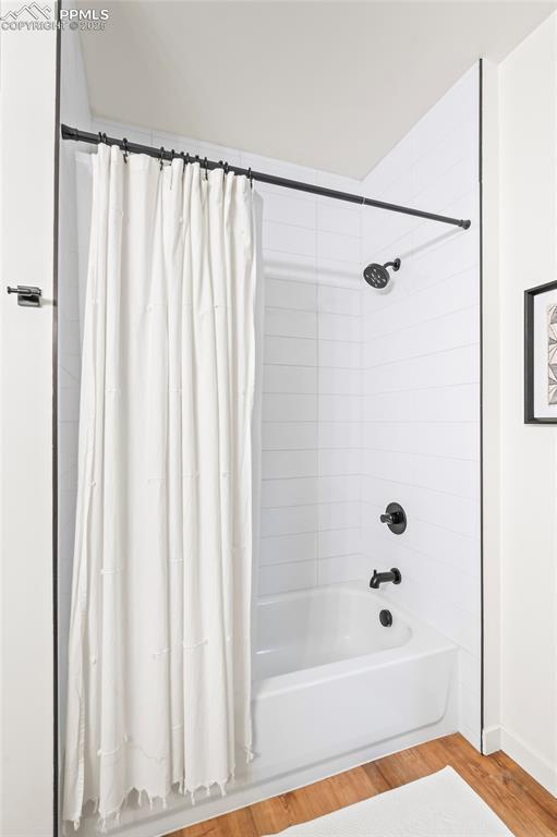 bathroom featuring shower / bath combination with curtain and wood-type flooring