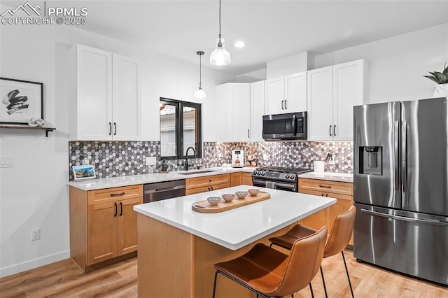 kitchen featuring white cabinets, a center island, sink, and stainless steel appliances