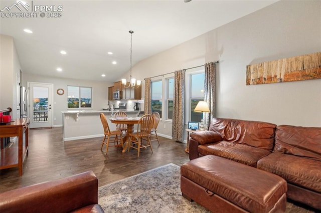 living room featuring lofted ceiling, dark hardwood / wood-style floors, and an inviting chandelier