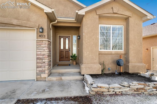 entrance to property with a garage, stone siding, and stucco siding