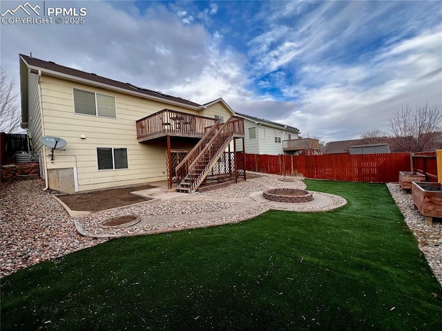 rear view of property featuring a patio area, a yard, an outdoor fire pit, and a wooden deck