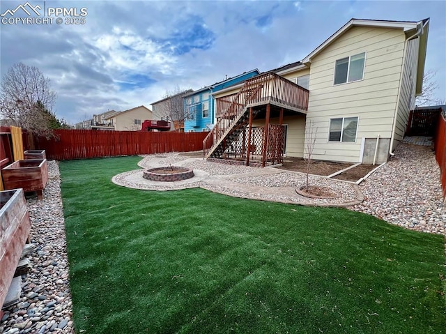 back of property with a fire pit, a patio area, a deck, and a yard