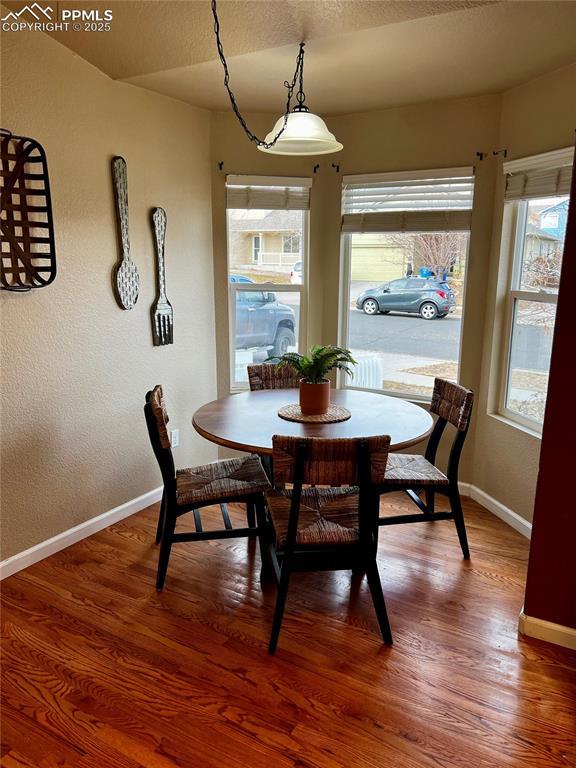 dining area with hardwood / wood-style flooring and a textured ceiling