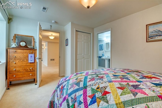 carpeted bedroom featuring ensuite bathroom and a closet