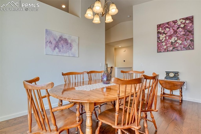 dining space with high vaulted ceiling, a chandelier, and hardwood / wood-style floors