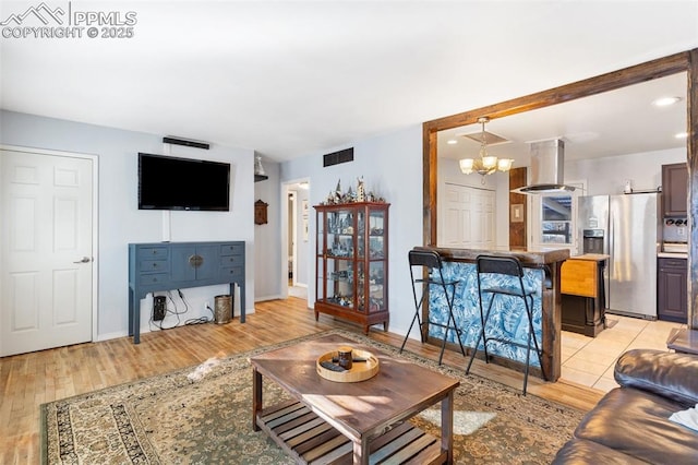 living room with a notable chandelier and light hardwood / wood-style flooring