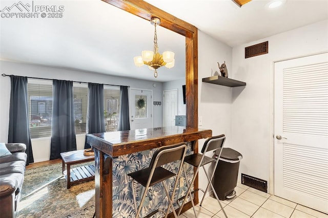 tiled dining room featuring a notable chandelier