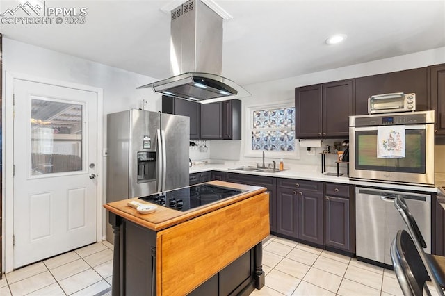 kitchen featuring sink, dark brown cabinets, stainless steel appliances, island exhaust hood, and light tile patterned flooring