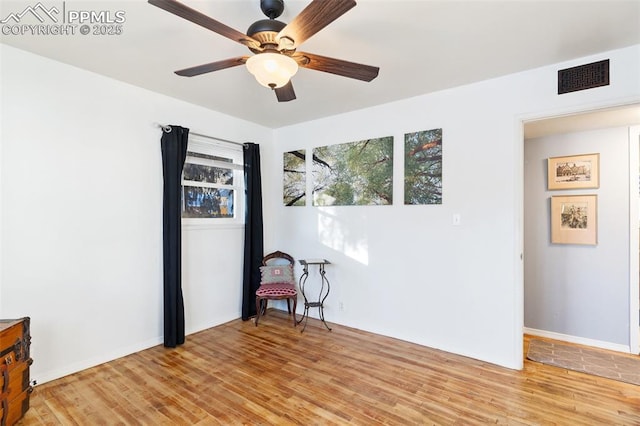 empty room with ceiling fan and light hardwood / wood-style flooring