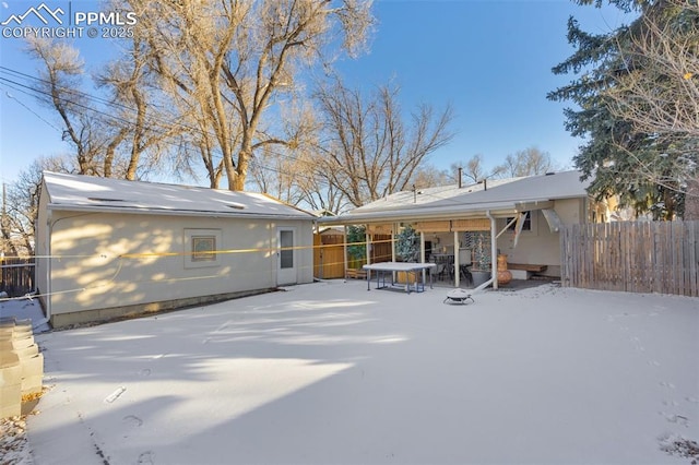 view of snow covered back of property