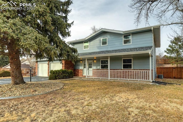 view of front property featuring covered porch, central AC unit, and a garage