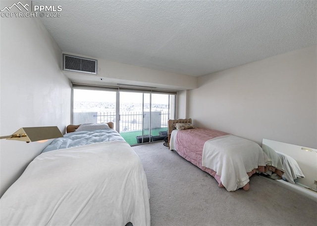 bedroom with access to outside, light carpet, and a textured ceiling