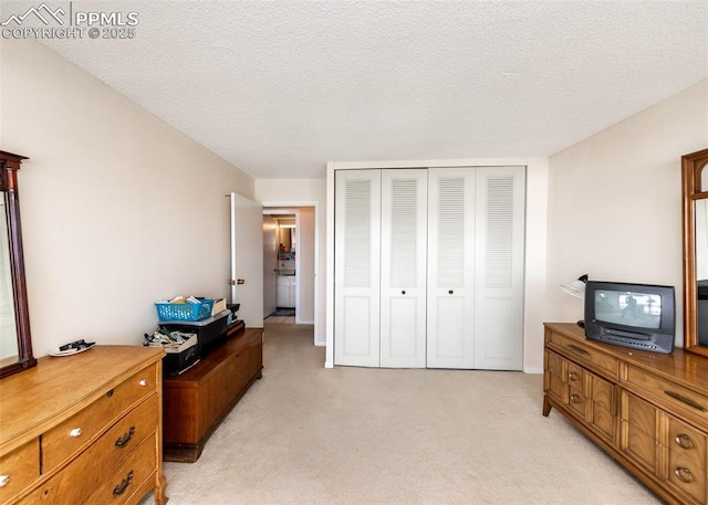 carpeted bedroom featuring a closet and a textured ceiling