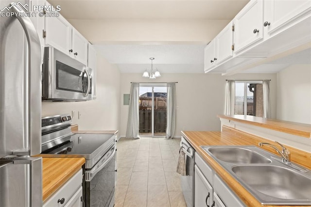 kitchen featuring pendant lighting, white cabinetry, sink, and stainless steel appliances