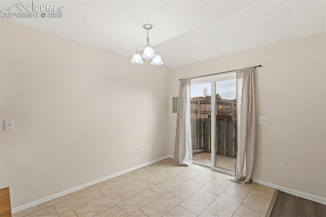 tiled empty room featuring a textured ceiling and an inviting chandelier