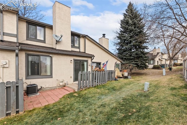 back of house featuring a lawn and central AC unit