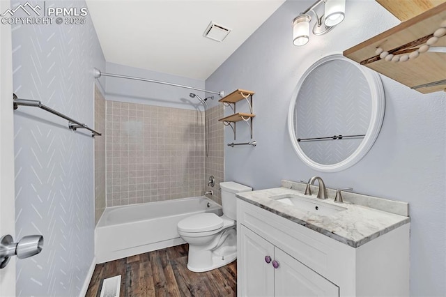 full bathroom featuring tiled shower / bath, wood-type flooring, toilet, and vanity