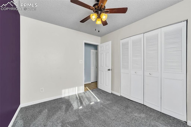 unfurnished bedroom featuring ceiling fan, a closet, a textured ceiling, and dark colored carpet