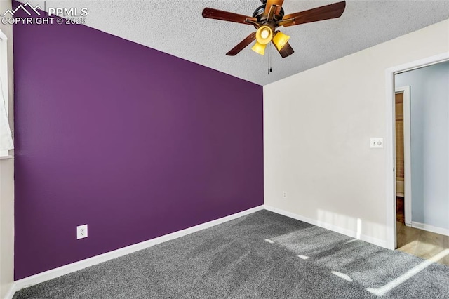 carpeted empty room with ceiling fan and a textured ceiling