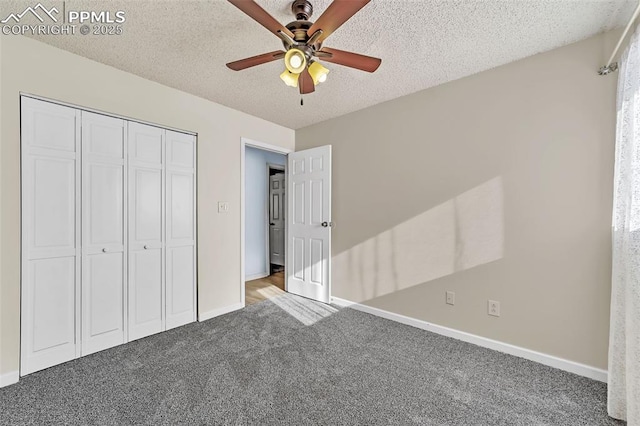 unfurnished bedroom featuring ceiling fan, a closet, carpet flooring, and a textured ceiling