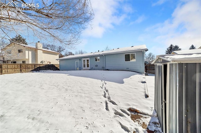 view of snow covered rear of property