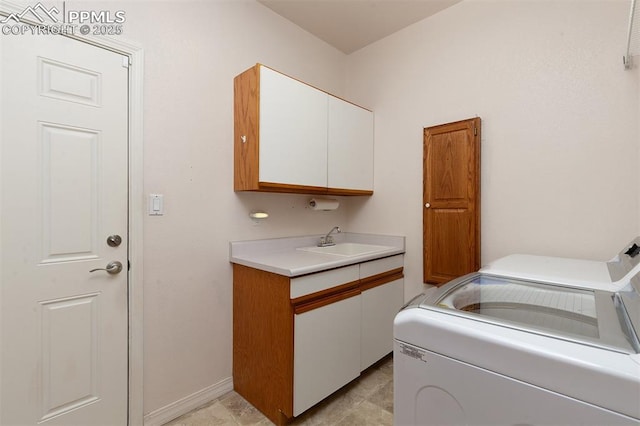 laundry room with cabinets, washer and clothes dryer, and sink