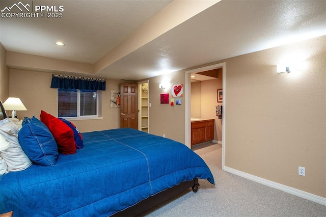 bedroom featuring light carpet and ensuite bathroom