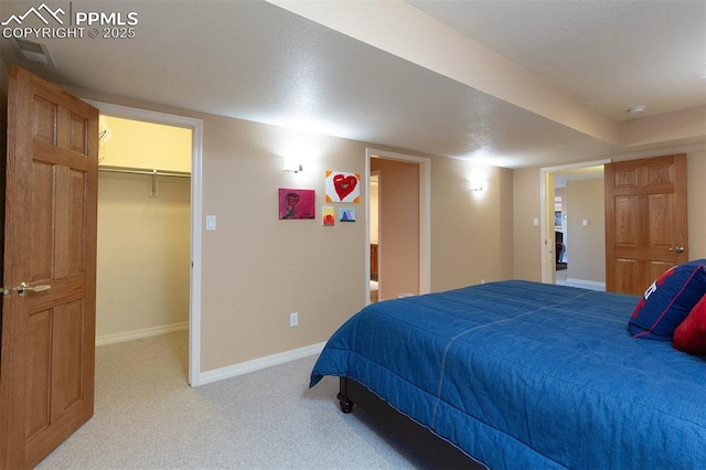 bedroom with a spacious closet, light carpet, and a closet