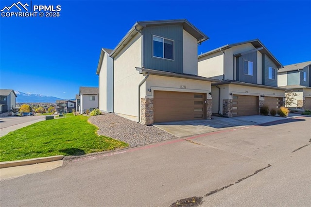 view of front of home with a mountain view, a garage, and a front yard