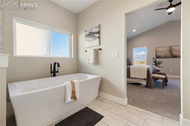 bathroom with a washtub, ceiling fan, plenty of natural light, and vaulted ceiling