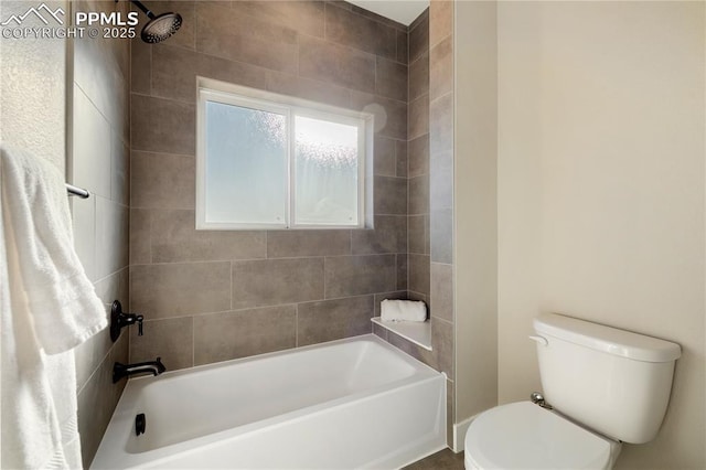 bathroom featuring toilet and tiled shower / bath