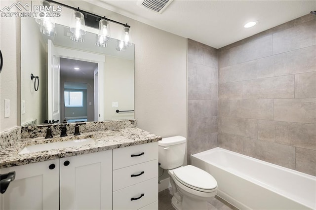 full bathroom featuring vanity, tiled shower / bath combo, and toilet