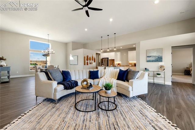 living room featuring ceiling fan with notable chandelier and dark hardwood / wood-style floors