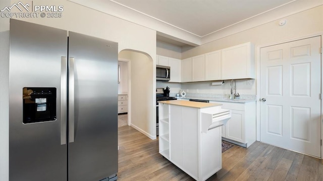 kitchen featuring a center island, light countertops, appliances with stainless steel finishes, wood finished floors, and white cabinets