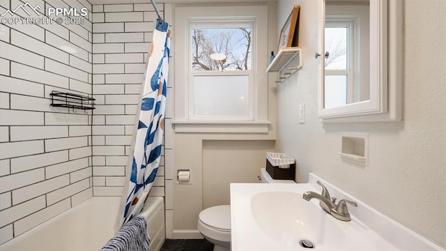 bathroom featuring a sink, toilet, and shower / bathtub combination with curtain