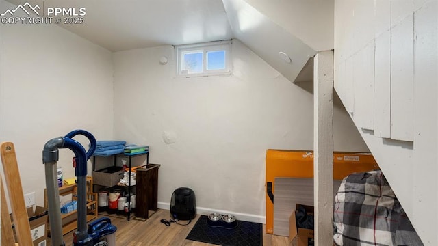 interior space with lofted ceiling, wood finished floors, and baseboards