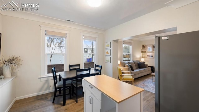 interior space featuring plenty of natural light, visible vents, baseboards, and wood finished floors