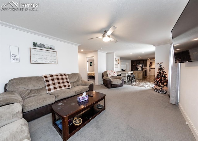 living room with ceiling fan, crown molding, and light carpet