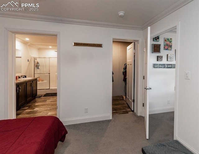 bedroom featuring dark colored carpet, ensuite bath, and ornamental molding