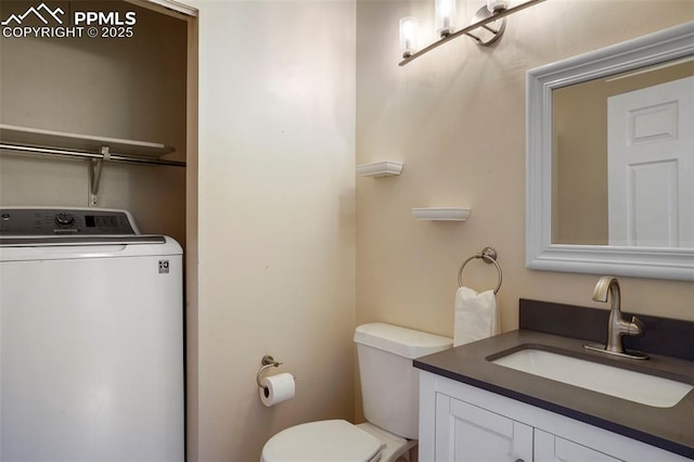 bathroom featuring vanity, toilet, and washer / dryer