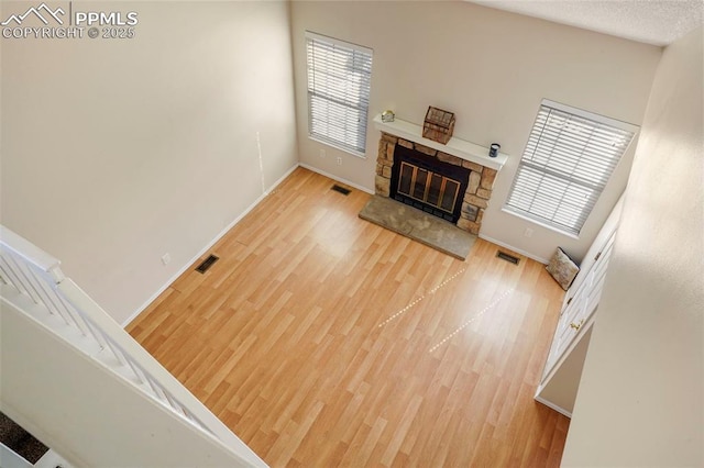 living room with wood-type flooring, a fireplace, a textured ceiling, and a wealth of natural light