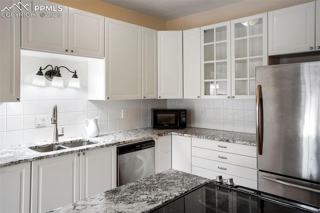 kitchen with appliances with stainless steel finishes, sink, decorative backsplash, and white cabinets