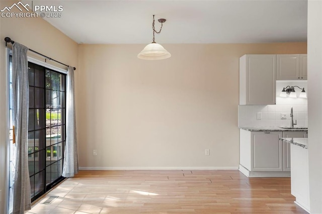 unfurnished dining area featuring light hardwood / wood-style floors and sink